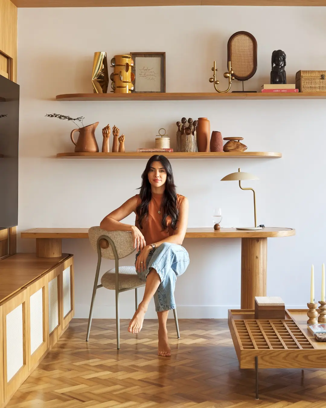 Gabriella Moreira em um interior com madeira e objetos artesanais